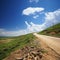 The road to the hill under a serene summer sky