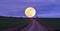 Road to the moon, the moon rises beyond the fields