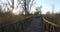 Road to the sun in a wetland park surrounded by autumn leading in two directions, left and right wooden pedestrian trails.