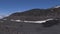 The road to the top of the volcano Etna. People descend from the mountain. Panoramic view of the surface of the volcano