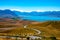 The road from the top of Mt John`s Observatory leading to Lake Tekapo and the snow capped Southern Alps