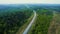 Road traffic, aerial view. Highway at forest with trees in spring. Cars and truck in motion on highway. Aerial above