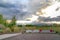 Road with traffic delineator posts and concrete road blocks under cloudy sky