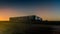 A road train runs along the Stuart highway at sunset