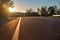 Road less traveled, low angle viewing, outdoor area. Sunset hours lighting the black paved road and mountains. Road