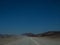 Road trip through dusty unpaved road among desert and mountain l