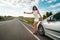Road trip, hitchhike, travel, gesture and people concept woman hitchhiking and stopping car with thumbs up gesture at