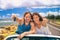 Road trip travel couple showing car keys on summer vacation. Happy young people adventure lifestyle. Carsharing