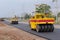 Road under construction, pneumatic tyred roller paver at asphalt