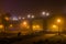 Road under footbridge misty night