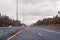 Road view through windshield car window with going rain drops during driving at speed. Unfocused highway. Autumn.