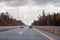 Road view through windshield car window with going rain drops during driving at speed. Unfocused highway. Autumn.