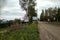 The road in the village before the rain. Traffic sign `Slippery road`.