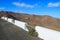 Road and white stone wall with view of desert landscape and volcanic mountains on Punta Entellada near Las Playitas, Fuerteventura