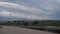 Road, windmills, vineyards and cloudscape at dusk