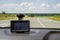 Road through the windshield against the background of a blurry navigator indicating the way to the driver