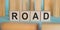 ROAD word written on wooden blocks on light blue background