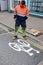 Road worker burning on a white cycleway sign.