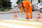 Road worker marking street lines zebra crossing