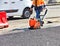 A road worker during road repair compaction of asphalt with a gasoline vibratory compactor