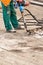 A road worker smashes old asphalt with a pneumatic jackhammer at a work site