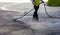 Road worker spraying bitumen emulsion