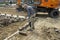 Road worker sweeps sand between cobblestones