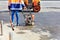 A road worker uses a gasoline vibratory compactor, a vibratory roller and an old broom to repair the road