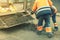 Road workers in bright orange reflective uniforms use shovels to scrape accumulated sand. maintenance of road and