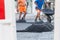 Road workers distribute the hot asphalt on the road with shovels and wheelbarrows, Germany