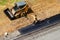 Road workers level the asphalt on the ground and lay it with a manual roller and excavator, top view