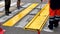 Road workers put paint on a crosswalk sign