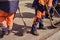 Road workers in uniform with shovels change the asphalt