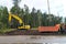 Road works, bulldozer and dump truck widen the road