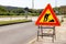 Road works sign for construction works in city street. Road under construction traffic sign. Traffic, warning sign road repairing.