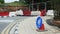 Roadblock ahead with detour pedestrian blue sign on traffic cone. Street under construction blocked by barriers and fence. Road co