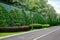 Roadside of asphalt bike path with drainage concrete canal and ditch with green plants.