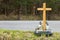 A roadside memorial cross with a candles