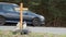 A roadside memorial cross with a candles commemorating the tragic death