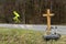 A roadside memorial cross with a candles commemorating the tragic death