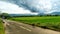 On the roadside there were dark clouds on green hills and green vegetation