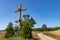 A roadside wooden cross in Central Europe. Christian cross standing by a dirt road