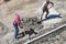 Roadway repair. Two handymen laying curbs on road on summer day.