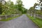 Roadway with a row of pollarded trees in front of a dry stone wall at an English country house