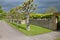 Roadway with a row of pollarded trees in front of a dry stone wall at an English country house