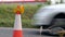 Roadworks cone flashing on UK motorway at evening with traffic passing