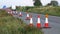 Roadworks cone flashing on UK motorway at evening with traffic passing