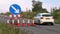 Roadworks cone flashing on UK motorway at evening with traffic passing