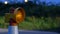 Roadworks cone flashing on UK motorway at night with traffic passing