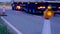Roadworks cone flashing on UK motorway at night with traffic passing
